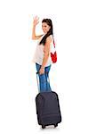 Smiling pretty woman carrying travel suitcase and waving goodbye. Isolated on white.