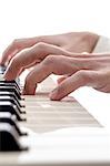 Closeup of pianist playing digital piano isolated over white background.
