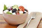 fresh greek salad in clay bowl, on table