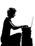 one caucasian young teenager silhouette boy or girl sitting computer computing laptop books full length in studio cut out isolated on white background