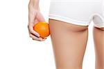 Woman with an orange showing a perfect skin without cellulitis