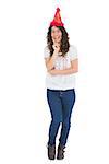 Smiling casual brunette with party hat posing on white background