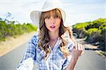 Trendy young woman posing  and looking at camera while walking on the road in summertime