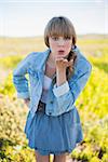 Trendy young woman in a sunny arid land sending kiss to camera