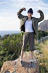 Woman hiking and showing her strength looking at camera in the countryside