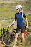 Blonde woman with bike wearing helmet in the country