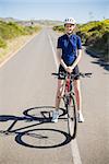 Smiling woman with bike on highway looking at camera