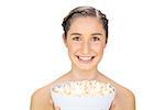 Smiling natural model holding popcorn on white background