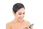 Attractive brunette using a smartphone on white background