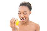 Cheerful natural model holding orange on white background