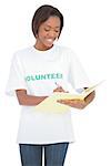 Cheerful volunteer woman writing on notebook on white background