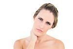 Upset woman looking at camera with a sore neck against white background