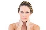 Disgruntled woman looking at camera with a sore neck against white background