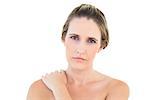 Disgruntled woman looking at camera with a sore shoulder against white background