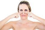 Pretty woman pressing blackhead on her nose posing on white background