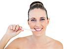 Smiling pretty woman brushing her teeth on white background