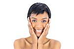 Joyful black haired woman posing holding her head on white background