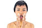 Upset black haired woman shouting with hands around the mouth on white background