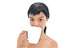 Cute black haired woman drinking a cup of coffee on white background