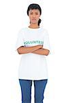 Depressed black haired volunteer posing with crossed arms on white background