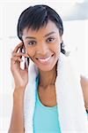 Gorgeous black haired woman calling someone with her mobile phone in a living room