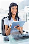 Cute businesswoman using a tablet pc in office