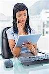Pensive businesswoman using a tablet pc in office