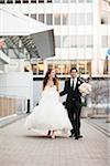 Bride and Groom walking towards camera along walkway in City Park on Wedding Day, Toronto, Ontario, Canada