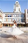 Portrait of Bride twirling in dress outdoors in City Park, Toronto, Ontario, Canada