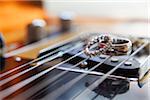 Close-up of guitar strings with wedding rings