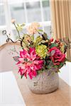 Floral centerpiece on table with burlap table runner
