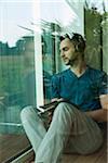 Young Man Listening to Music through Headphones at Home, Mannheim, Baeden-Wurttemberg, Germany