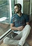 Young Man Listening to Music through Headphones at Home, Mannheim, Baeden-Wurttemberg, Germany