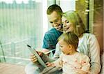 Family using Tablet Computer by Window at Home, Mannheim, Baden-Wurttemberg, Germany