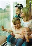 Family Looking out Window at Home, Mannheim, Baden-Wurttemberg, Germany