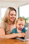 Young Woman and Baby Girl using Computer, Mannheim, Baden-Wurttemberg, Germany