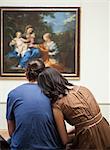 France, Paris, Young couple watching paintings in Louvre Museum