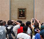 France, Paris, Tourists photographing Mona Lisa painting