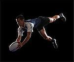 Studio portrait of teenage boy (14-15) with rugby ball