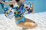 USA, Utah, Orem, Young woman under water wrapped in colorful textile