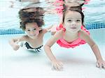 USA, Utah, Orem, Boy (4-5) and girl (4-5) swimming in pool
