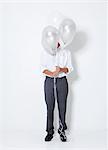 Young man hiding behind balloons at party