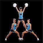 Studio shot of cheerleaders (16-17) assisting friend during performance