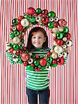 Studio portrait of girl (4-5) holding Christmas decoration