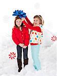 Studio portrait of girls (4-5, 6-7) standing in snow