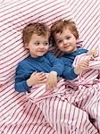 USA, Utah, Orem, Twin boys (2-3) wearing pajamas playing on bed