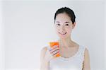 Young woman with vegetable juice smiling at camera