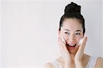 Young woman putting face-wash foam