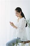 Young woman sitting with smart phone in the living room