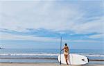 Woman on beach with paddle board